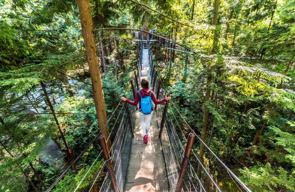 Tourist walking in famous attraction Capilano Suspension Bridge in North Vancouver, British Columbia